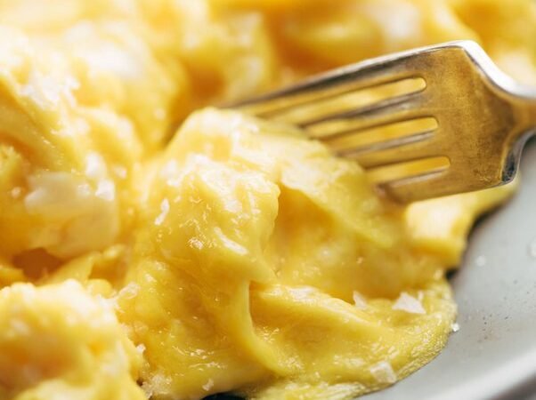 How do restaurants make scrambled eggs taste better than homemade?